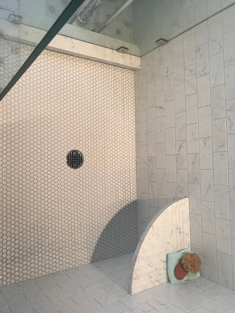 Luxurious walk-in shower with marble tiles and hexagonal floor in New Seabury, Mashpee