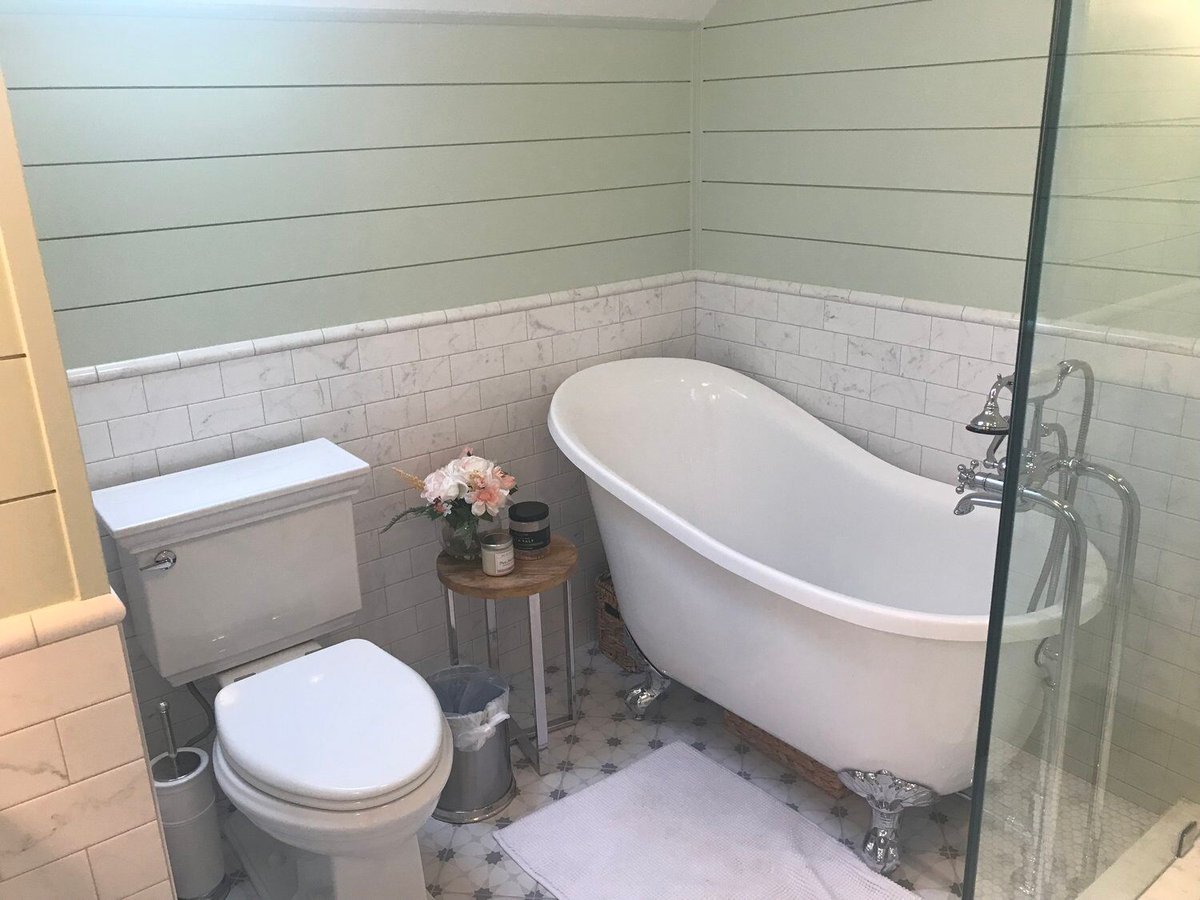 Spacious bathroom with freestanding clawfoot tub and glass shower in New Seabury remodel