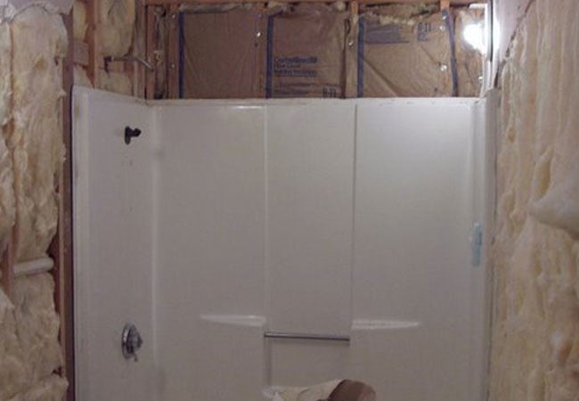 Bathroom under renovation with exposed insulation in New Seabury remodel by At Design Remodel, Mashpee