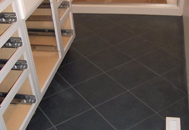 Black tile flooring installation progress in New Seabury bathroom remodel by At Design Remodel, Mashpee