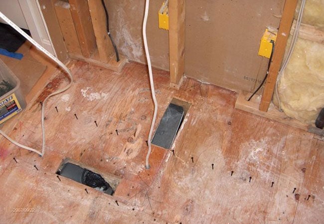 Floor and wiring preparation during bathroom remodel in New Seabury by At Design Remodel, Mashpee