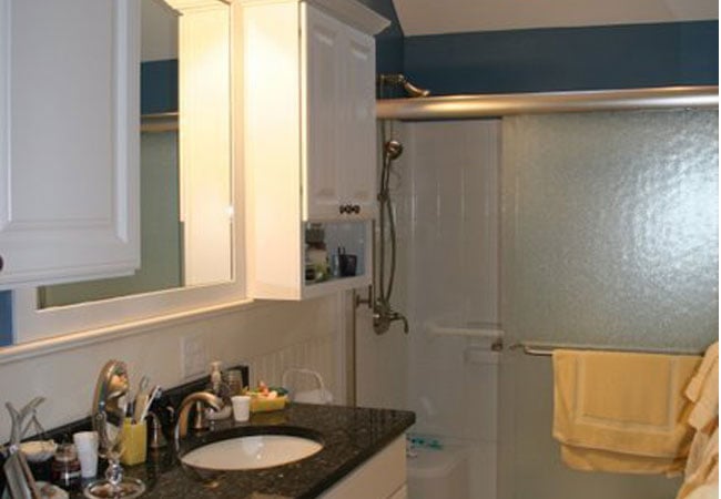 Granite countertop and sliding shower door in New Seabury bathroom remodel by At Design Remodel, Mashpee