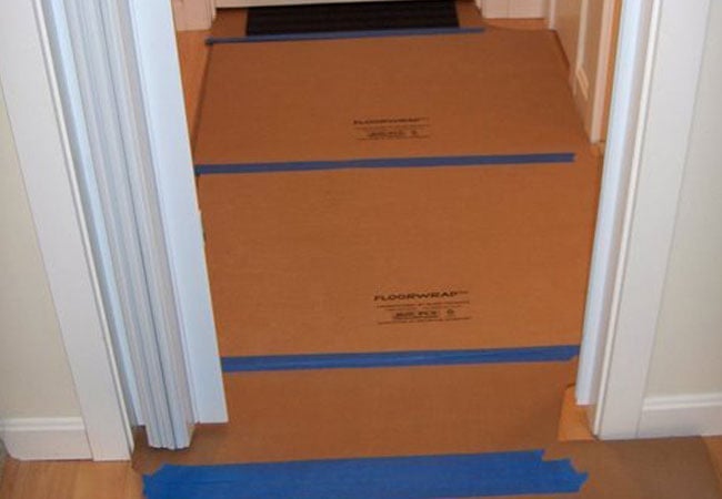 Hallway floor covered for protection during New Seabury remodel by At Design Remodel, Mashpee