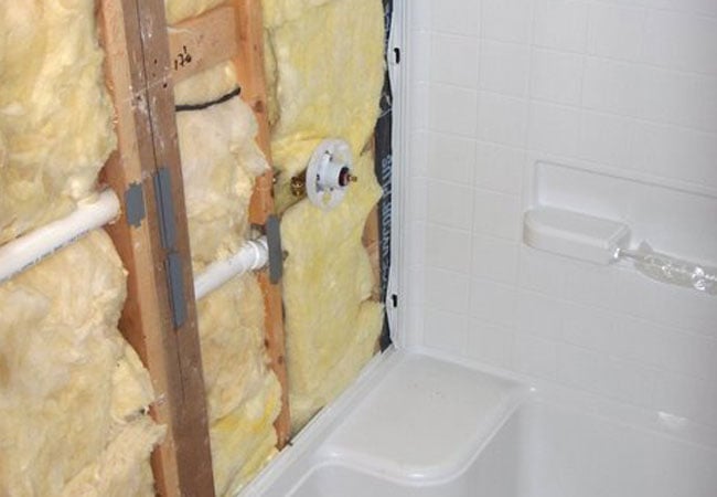 Partially installed bathroom wall with insulation during New Seabury remodel by At Design Remodel, Mashpee