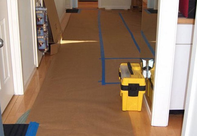 Protected floor with a toolbox during New Seabury remodel by At Design Remodel, Mashpee