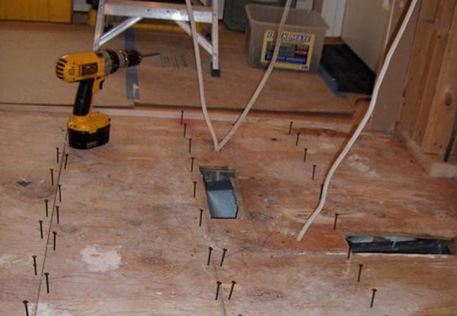 Tools and screws on the floor during bathroom renovation in New Seabury by At Design Remodel, Mashpee