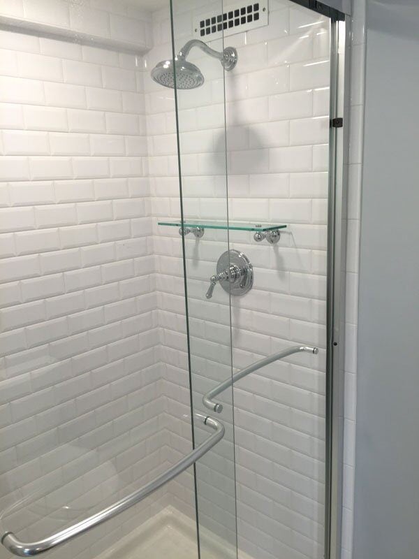 Newly remodeled bathroom with a glass-enclosed shower by At Design Remodel in Mashpee