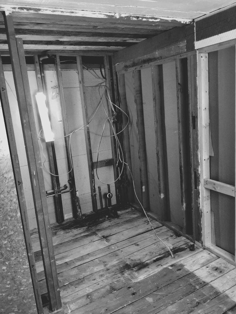 Remodeled bathroom during construction, showing exposed framing and wiring in Mashpee