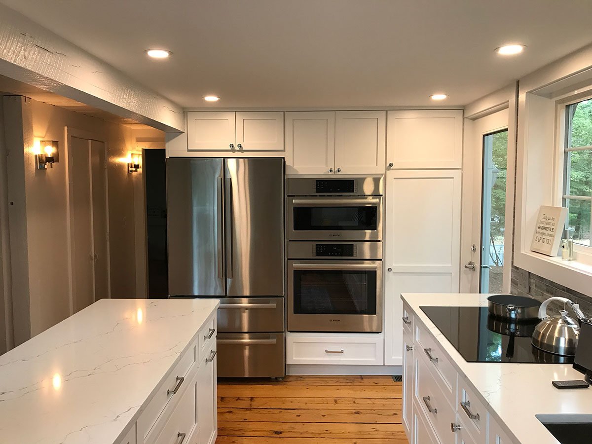 Elegant kitchen remodel with white cabinets and island in a home renovation on Greensward Road, New Seabury