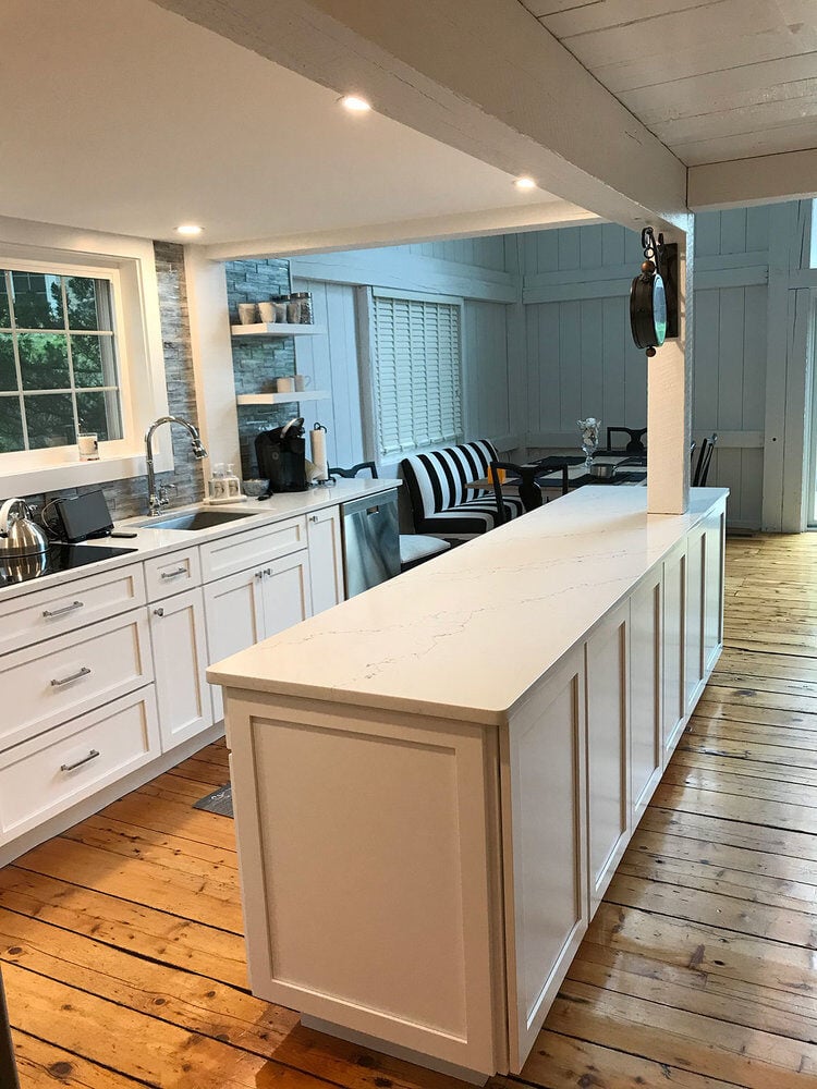 Open kitchen remodel with large center island and white cabinetry in a New Seabury home renovation