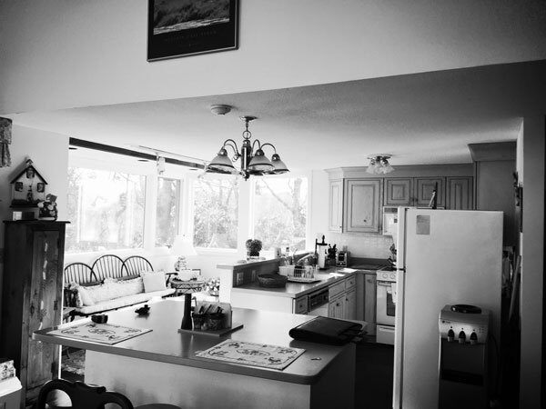 Before remodeling, this North Falmouth kitchen features a functional island and ample natural light