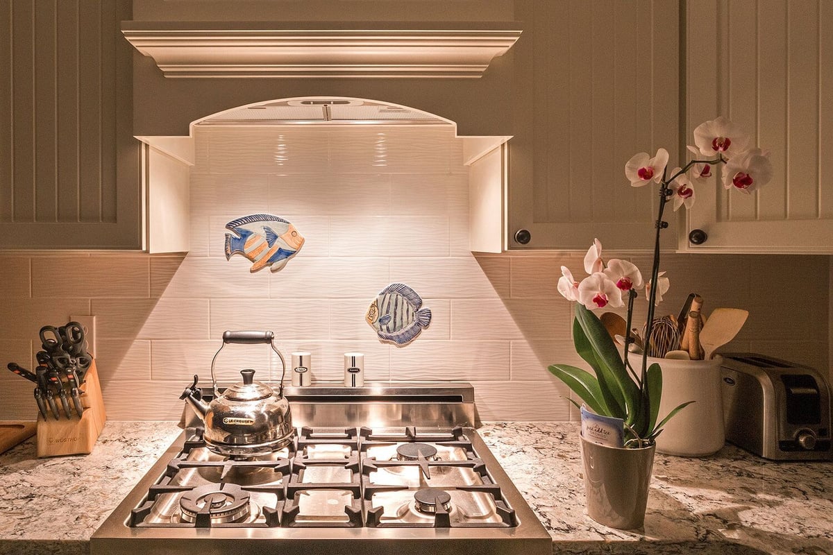 Coastal-themed backsplash with stainless steel stove, part of a North Falmouth kitchen remodel