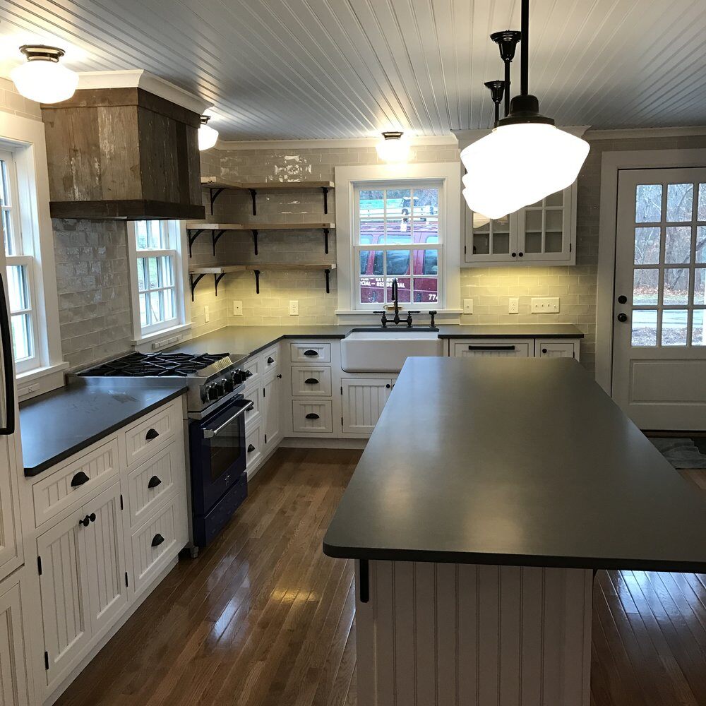 Falmouth kitchen remodel featuring a large kitchen island and white cabinetry, completed by At Design Remodel in Mashpee