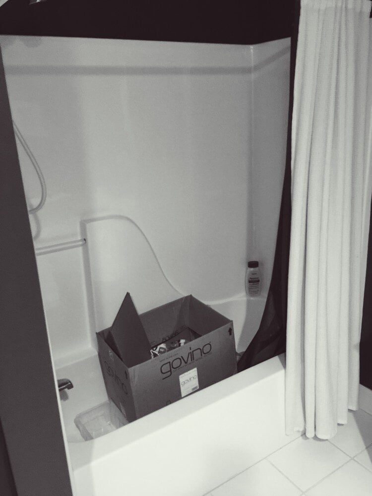 Bathroom in mid-renovation with a box of tools, handled by At Design Remodel