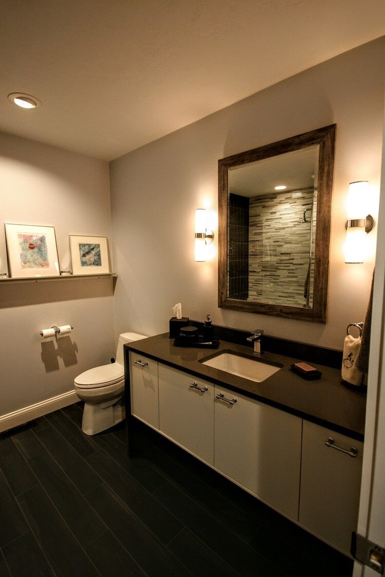 Contemporary bathroom with dark vanity and framed mirror, completed by At Design Remodel in Mashpee, MA