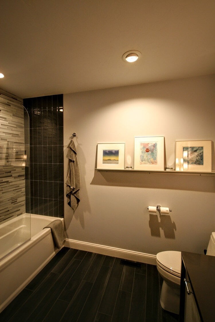 Stylish bathroom with contemporary artwork and tiled shower, designed by At Design Remodel in Mashpee, MA