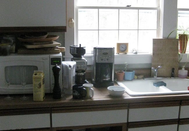 Coffee maker and plants near a kitchen window, part of a West Falmouth remodel by At Design Remodel