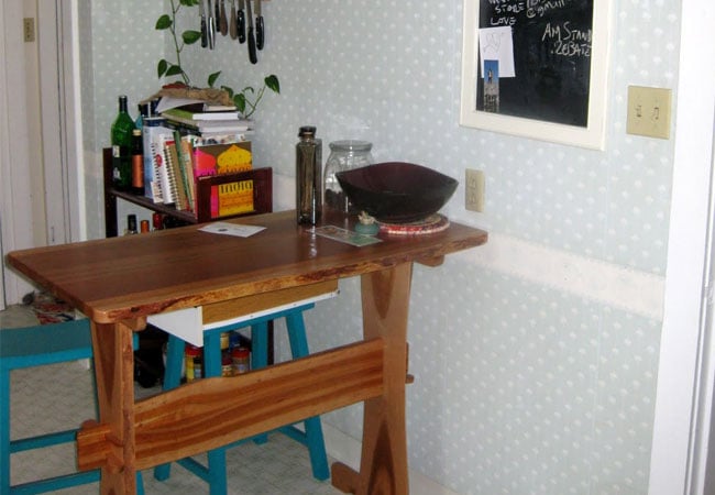 Compact dining area with a wooden table in the process of remodeling a West Falmouth kitchen by At Design Remodel