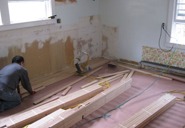 Contractor installing new flooring in a West Falmouth kitchen remodel by At Design Remodel, Mashpee