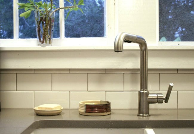 Kitchen sink with a stainless steel faucet near a bright window, part of a West Falmouth remodel by At Design Remodel