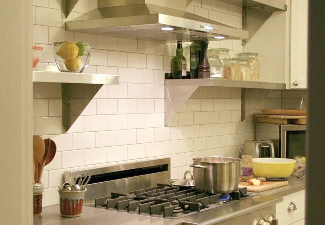 Stainless steel stovetop with white subway tile backsplash in a remodeled kitchen in West Falmouth by At Design Remodel