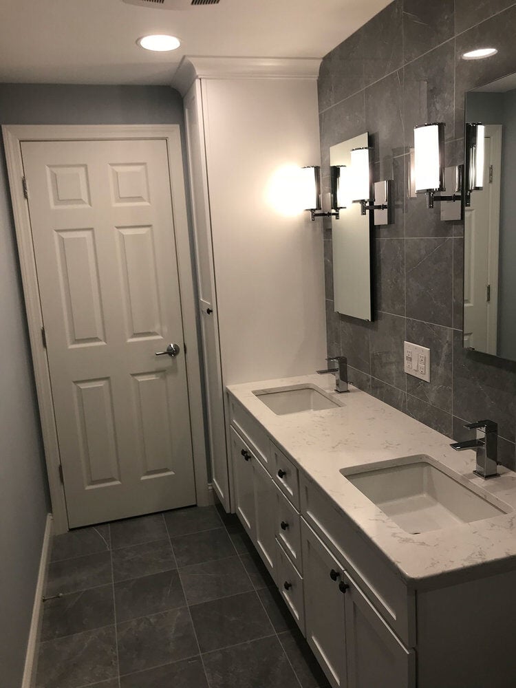 Double sink vanity with gray tiled walls in a Yarmouthport bathroom remodel by At Design Remodel