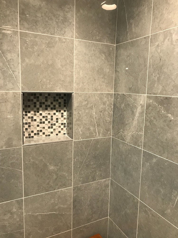 Mosaic niche in a gray tiled shower wall in a Yarmouthport bathroom by At Design Remodel