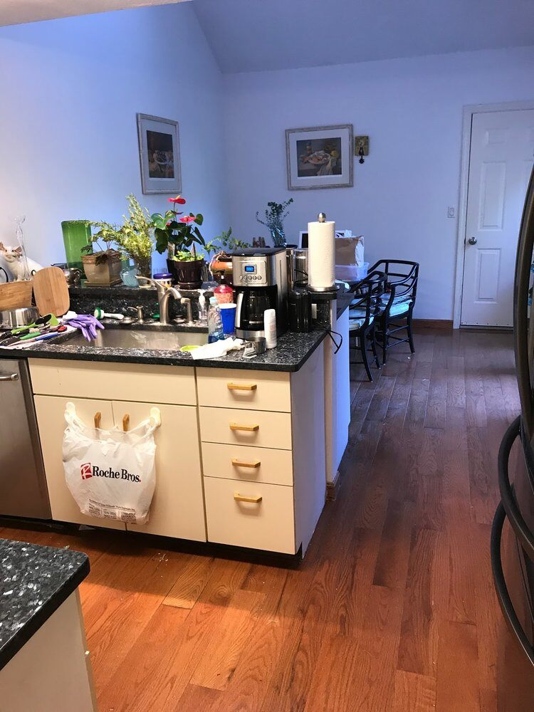 Kitchen view with cluttered surfaces before a renovation in Yarmouthport home by At Design Remodel, Mashpee